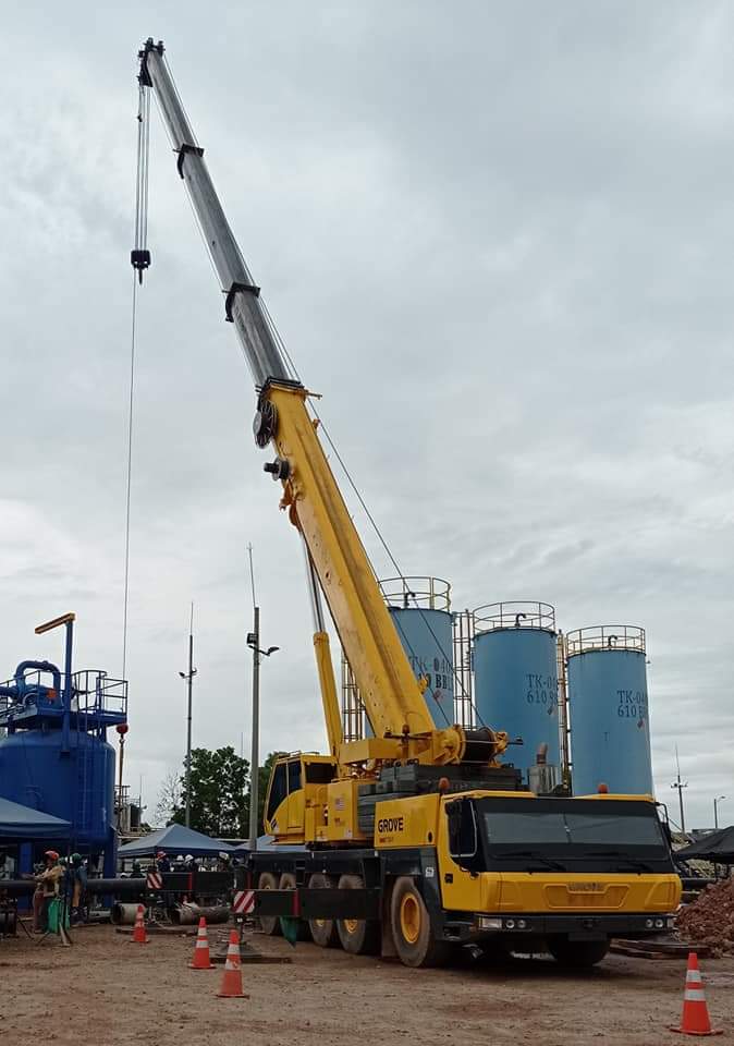 Grúa Grove junto a tanques industriales